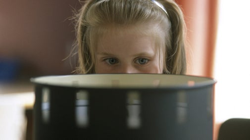 Little girl looking at a zoetrope, a Victorian optical illusion.
